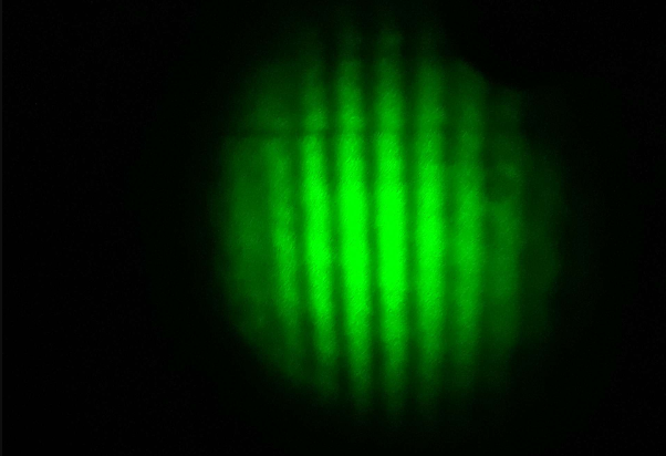 Circular fringe pattern  green laser rings on dark background